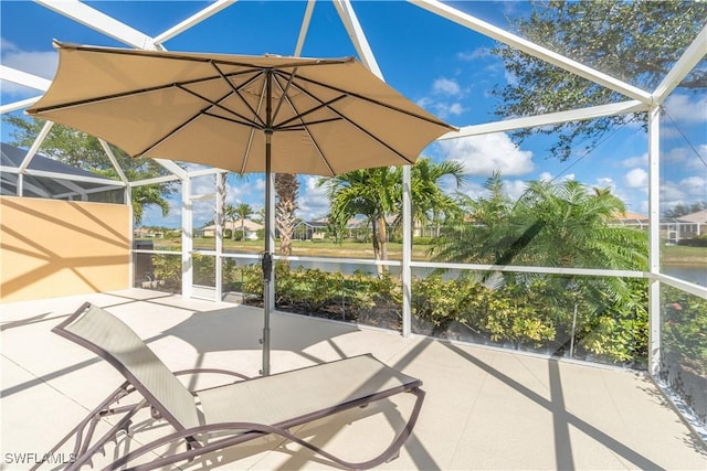 view of patio with a lanai and a water view