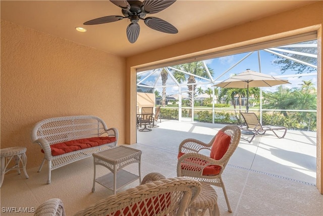 view of patio featuring ceiling fan and glass enclosure