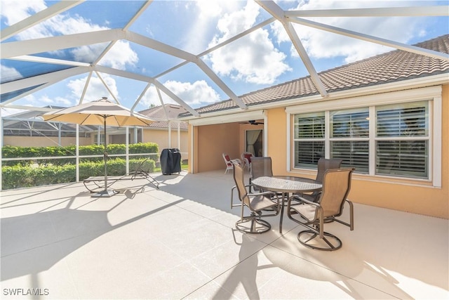 view of patio / terrace with grilling area, ceiling fan, and glass enclosure