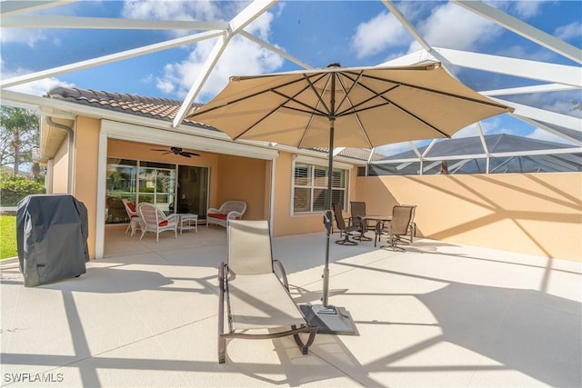 view of patio with ceiling fan, a grill, and glass enclosure