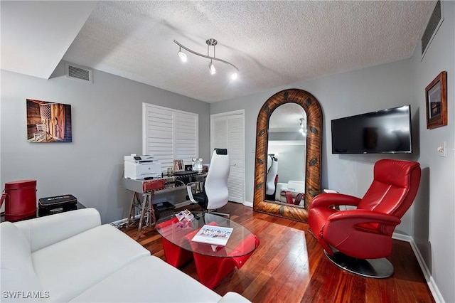 living room with a textured ceiling and hardwood / wood-style flooring