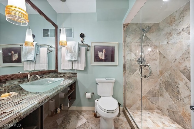 bathroom with sink, toilet, and an enclosed shower