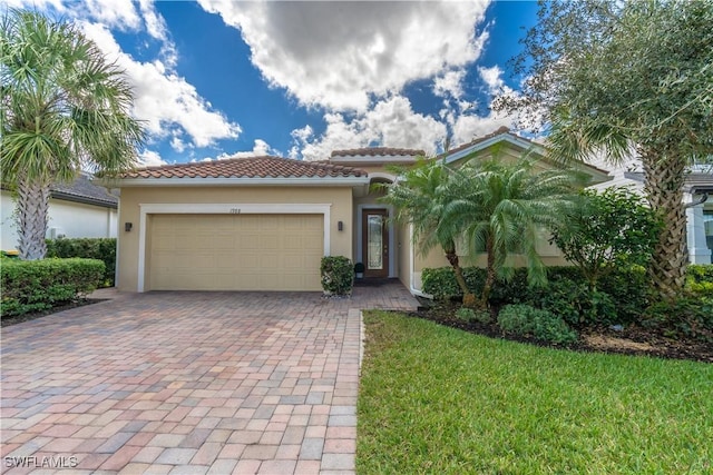 mediterranean / spanish-style house featuring a garage and a front yard