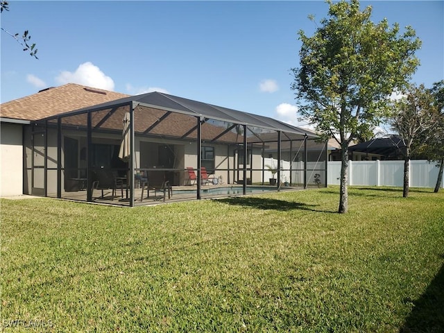 back of house featuring a yard, a lanai, a fenced in pool, and a patio