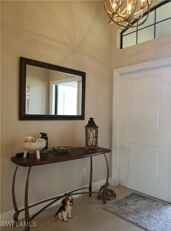 tiled foyer entrance with an inviting chandelier