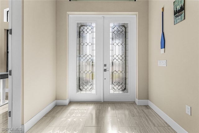 foyer featuring french doors and baseboards