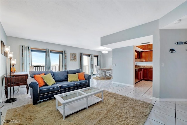 living area with a healthy amount of sunlight, light tile patterned floors, and baseboards