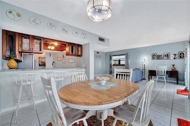 dining room with light tile patterned floors, baseboards, and visible vents