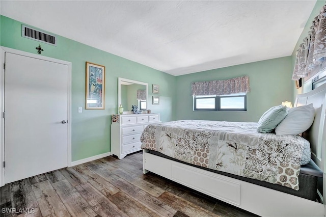 bedroom featuring baseboards, visible vents, and dark wood-style flooring