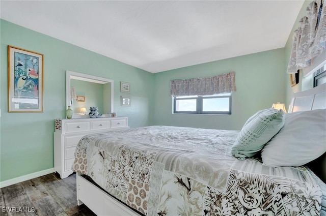 bedroom with baseboards and wood finished floors