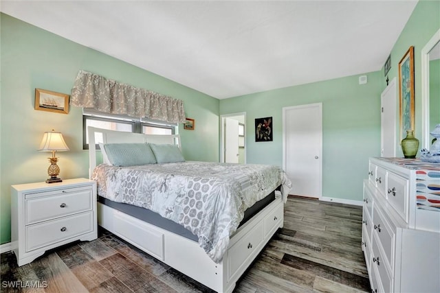 bedroom featuring baseboards and dark wood finished floors