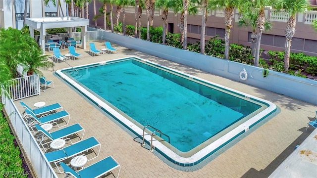 view of swimming pool featuring a patio area and fence