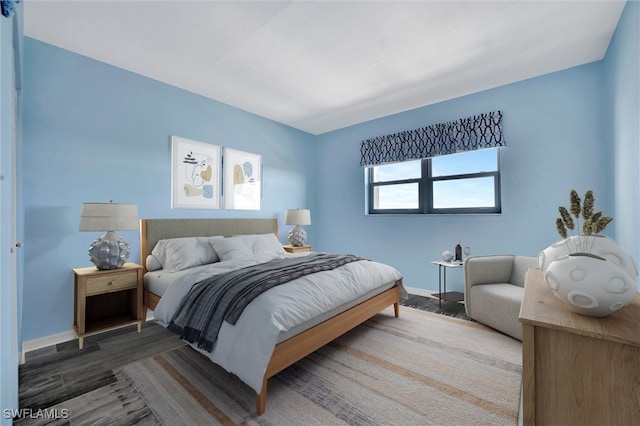 bedroom featuring baseboards and wood finished floors