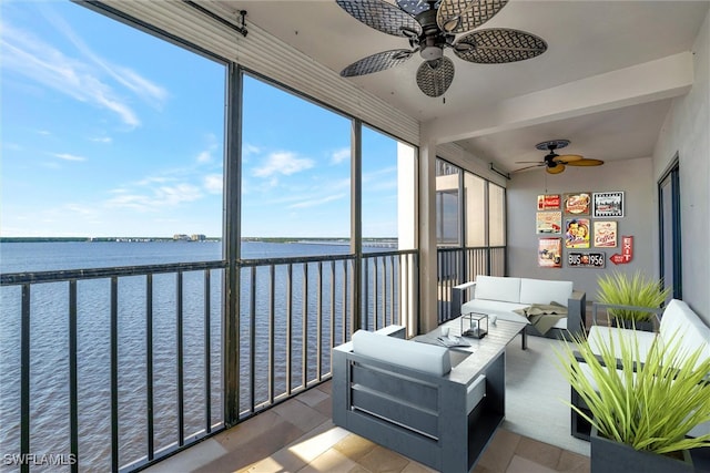 sunroom / solarium featuring a water view and ceiling fan