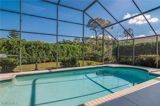 view of swimming pool featuring glass enclosure