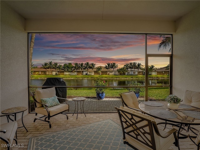 sunroom / solarium with a water view