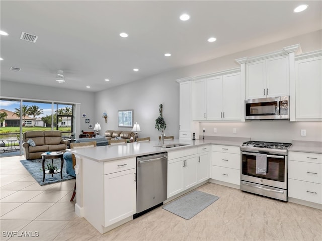 kitchen featuring stainless steel appliances, sink, white cabinets, and kitchen peninsula