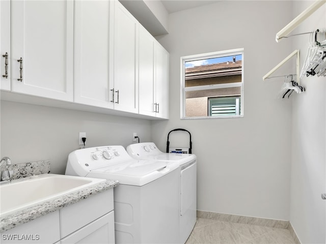 laundry area featuring separate washer and dryer, sink, and cabinets