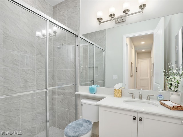 bathroom featuring vanity, an enclosed shower, and toilet