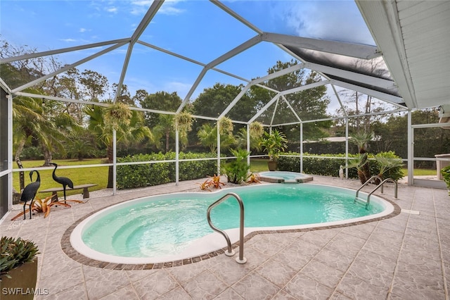 view of pool with a patio area, glass enclosure, and a pool with connected hot tub