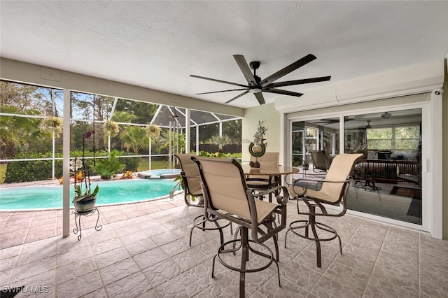 view of swimming pool featuring ceiling fan, a pool with connected hot tub, a lanai, and a patio area