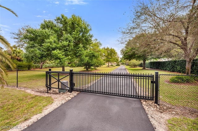 view of gate with a yard and fence