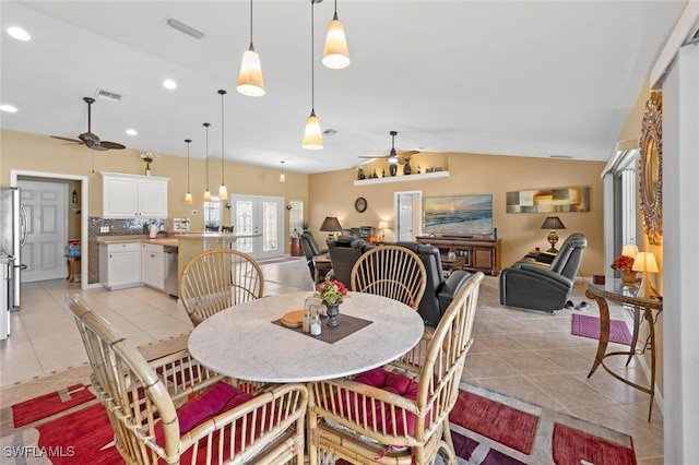 tiled dining area featuring french doors, ceiling fan, and lofted ceiling