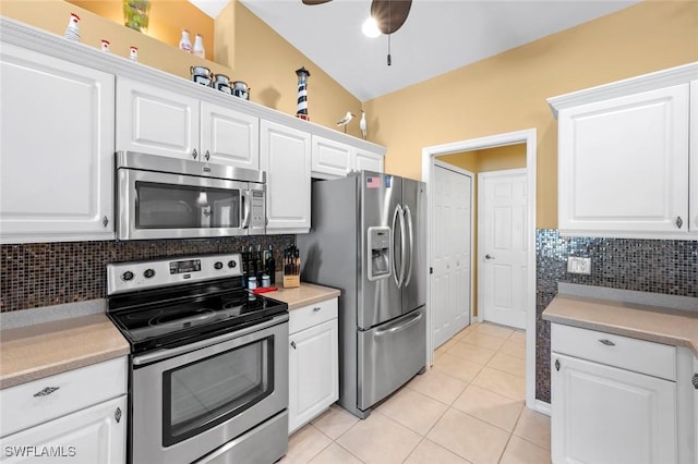 kitchen featuring light tile patterned floors, ceiling fan, stainless steel appliances, white cabinets, and decorative backsplash