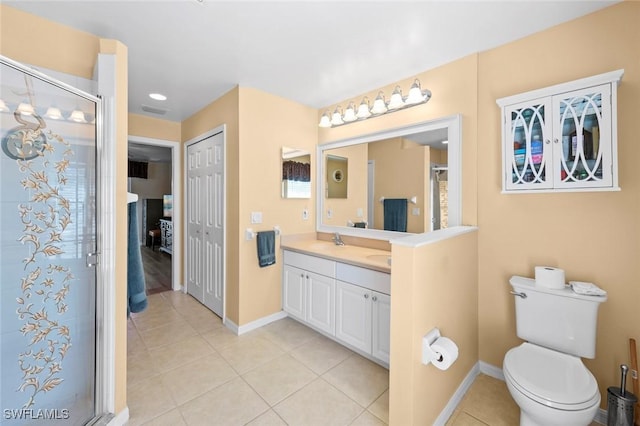 bathroom featuring walk in shower, vanity, toilet, and tile patterned flooring