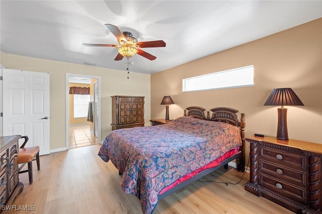 bedroom featuring ceiling fan, multiple windows, and light hardwood / wood-style flooring