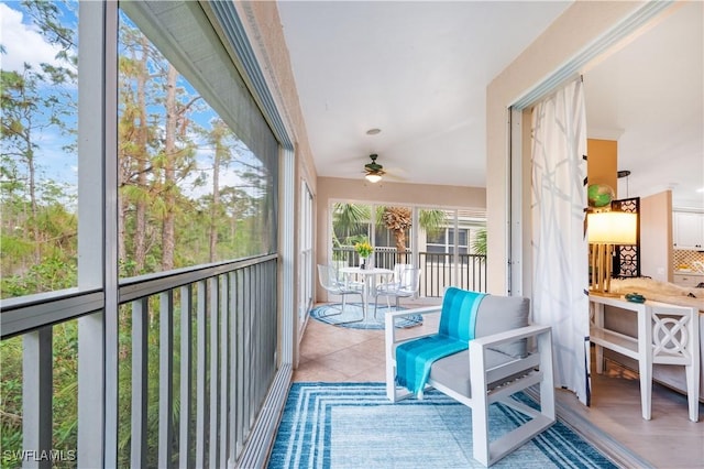 balcony featuring a sunroom and a ceiling fan