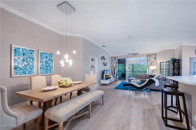 dining room with ceiling fan with notable chandelier, light wood-style flooring, and crown molding