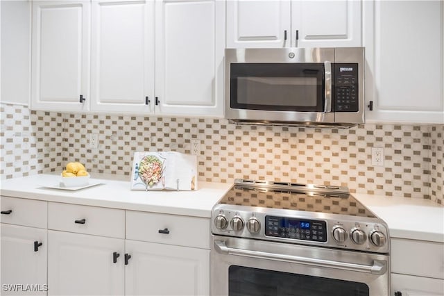 kitchen featuring stainless steel appliances, light countertops, white cabinets, and tasteful backsplash