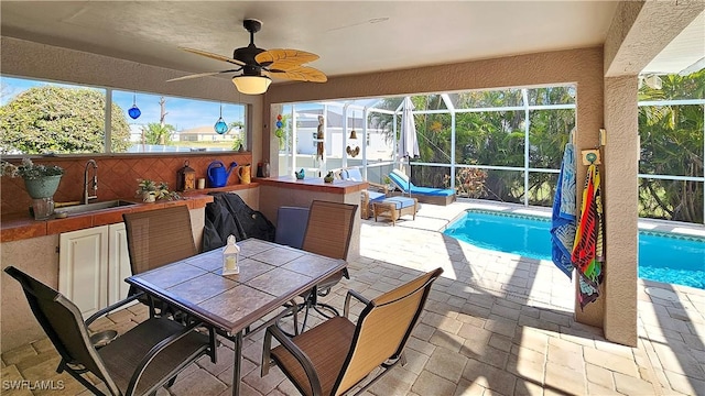 view of patio / terrace with ceiling fan, a wet bar, and glass enclosure