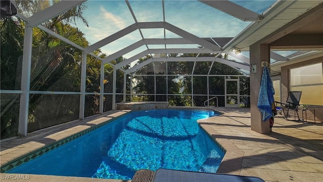 view of swimming pool featuring a patio and a lanai