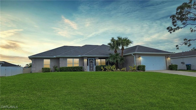 ranch-style home with a garage and a lawn