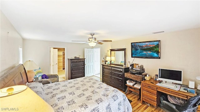 bedroom featuring hardwood / wood-style flooring, ceiling fan, ensuite bathroom, and a closet