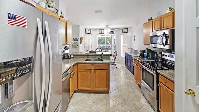 kitchen featuring sink, light tile patterned floors, appliances with stainless steel finishes, kitchen peninsula, and ceiling fan