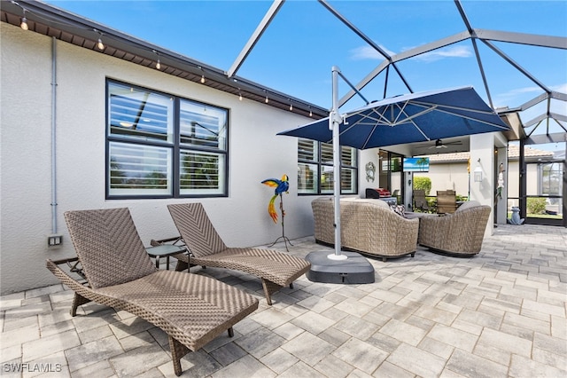 view of patio / terrace with glass enclosure, an outdoor living space, and a ceiling fan