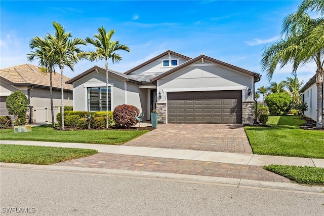 view of front of house featuring a garage, decorative driveway, a front lawn, and stucco siding