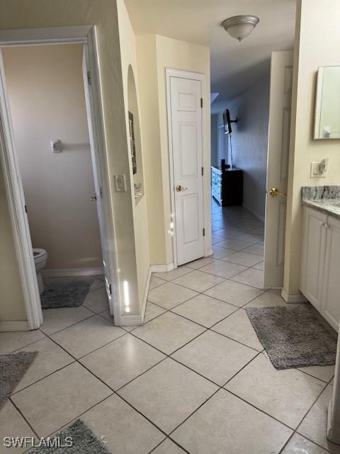 bathroom with tile patterned flooring, vanity, and toilet