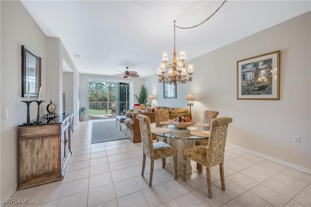 dining space with ceiling fan with notable chandelier, baseboards, and light tile patterned floors