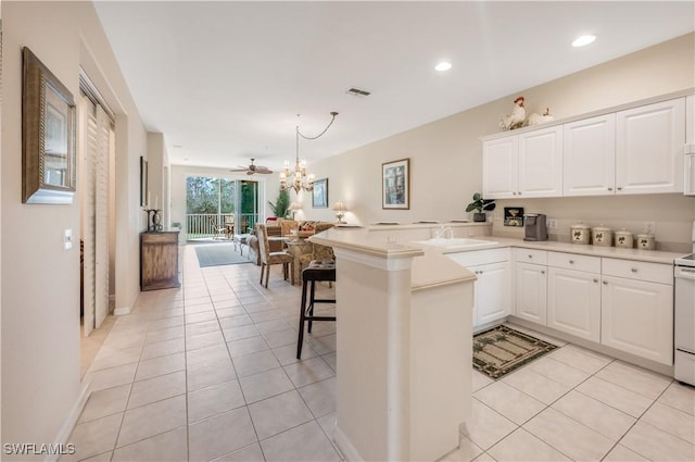 kitchen featuring open floor plan, visible vents, a peninsula, and light tile patterned floors