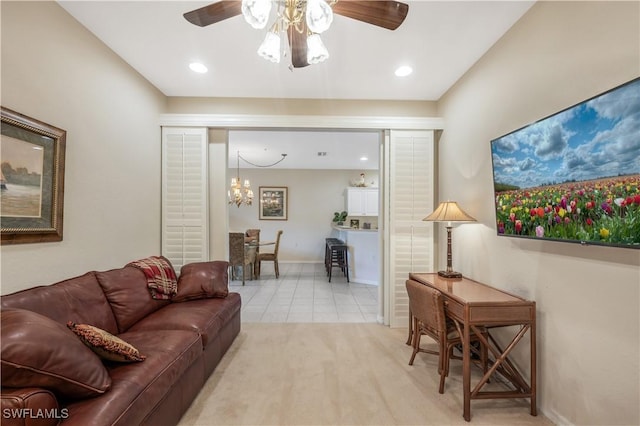 living area with light tile patterned floors, recessed lighting, baseboards, and ceiling fan with notable chandelier