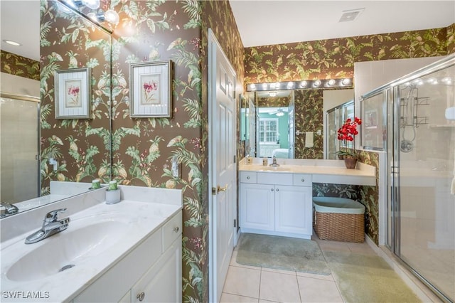 full bathroom featuring a sink, a shower stall, and wallpapered walls