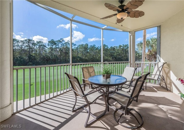 unfurnished sunroom with ceiling fan