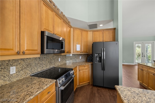 kitchen featuring appliances with stainless steel finishes, light stone counters, dark hardwood / wood-style floors, french doors, and tasteful backsplash