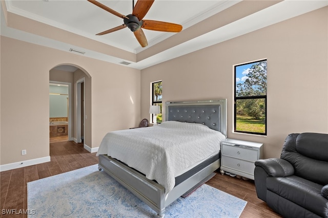 bedroom featuring ceiling fan, crown molding, dark hardwood / wood-style flooring, and a raised ceiling