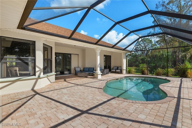 view of swimming pool with glass enclosure, outdoor lounge area, and a patio area