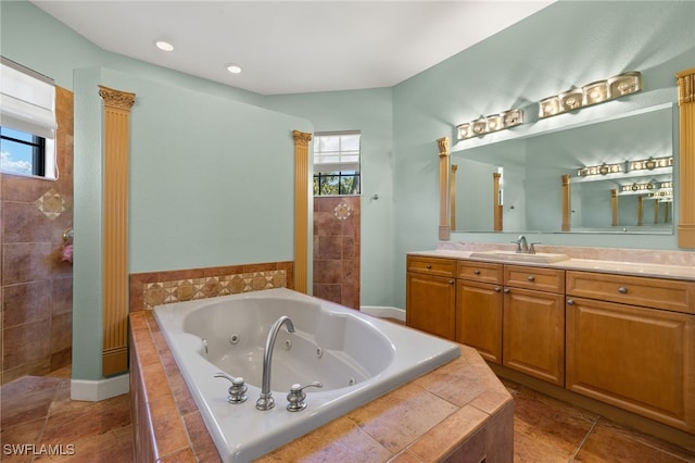 bathroom featuring vanity, tile patterned floors, and tiled bath